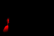 a person standing on top of a red object in the dark